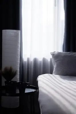 a bedroom with a bed and a table next to a window at Sleep with Me Bangkok - BTS Phra Khanong in Bangkok