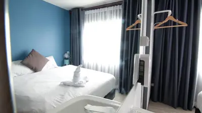 a bedroom with a bed with a white stuffed animal on it at Sleep with Me Bangkok - BTS Phra Khanong in Bangkok