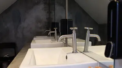 a row of sinks in a public bathroom at Sleep with Me Bangkok - BTS Phra Khanong in Bangkok