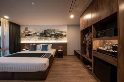a hotel room with a bed and a painting on the wall at Manhattan Hotel Bangkok in Bangkok