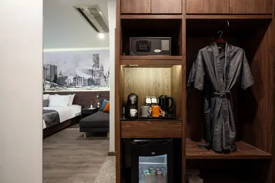 a room with a room with a robe and a bed at Manhattan Hotel Bangkok in Bangkok