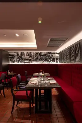 a restaurant with red booths and a table and chairs at Manhattan Hotel Bangkok in Bangkok