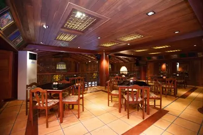 a dining room with tables and chairs in a restaurant at Chang Siam Inn in Bangkok
