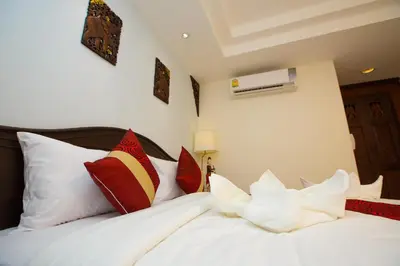 a bedroom with two beds with red and white pillows at Chang Siam Inn in Bangkok
