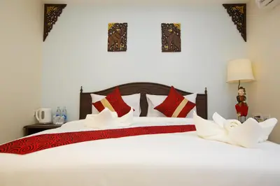 a bedroom with two beds with red and white pillows at Chang Siam Inn in Bangkok