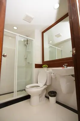 a bathroom with a toilet and a shower and a sink at Chang Siam Inn in Bangkok