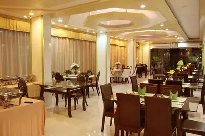 a dining room with tables and chairs in a restaurant at Visiting Card Hotel & Resort in Bangkok
