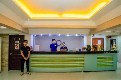 a man standing in front of a bar in a lobby at Visiting Card Hotel & Resort in Bangkok