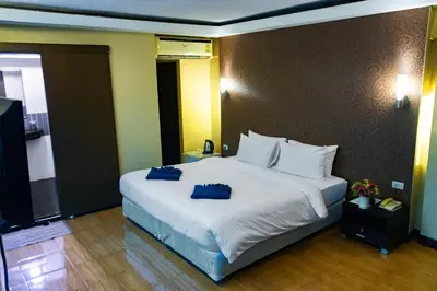 a bedroom with a large white bed with blue towels on it at Visiting Card Hotel & Resort in Bangkok