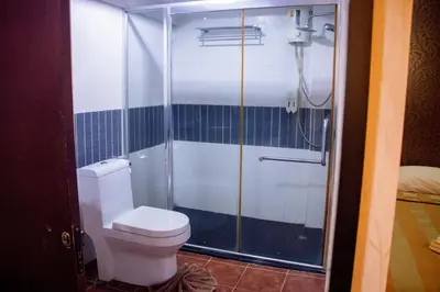 a bathroom with a toilet and a shower at Visiting Card Hotel & Resort in Bangkok