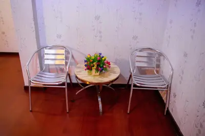 two chairs and a table with a vase of flowers on it at Visiting Card Hotel & Resort in Bangkok