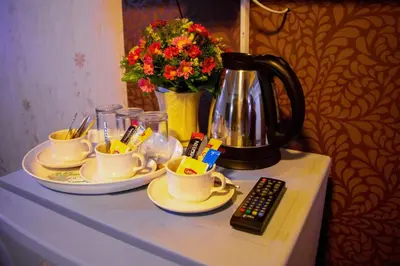 a table with cups and a coffee pot and a remote control at Visiting Card Hotel & Resort in Bangkok