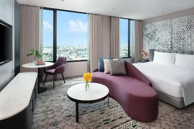 a hotel room with a large bed and a couch at Avani Sukhumvit Bangkok Hotel in Bangkok