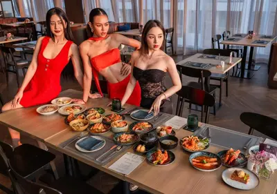 three women standing around a table with food on it at Avani Sukhumvit Bangkok Hotel in Bangkok