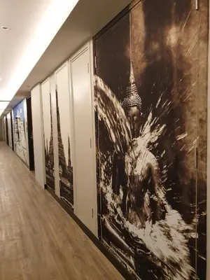 a hallway with large photographs on the wall at Aspira One Sutthisan in Bangkok