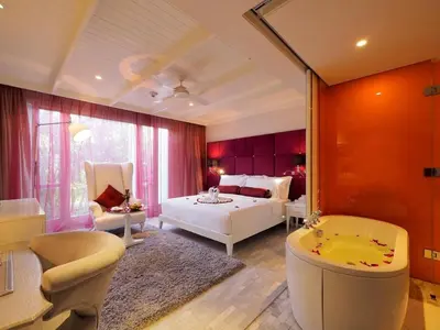 a bedroom with a bed and a tub in a room at Hua Chang Heritage Hotel in Bangkok