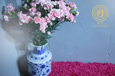 a blue and white vase with pink flowers in it at Hong hostel in Bangkok