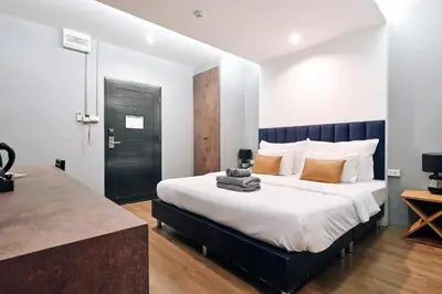 a bedroom with a large bed and a black door at Castle Black Bangkok in Bangkok