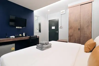 a bedroom with a white bed and a blue wall at Castle Black Bangkok in Bangkok