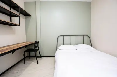a small bedroom with a bed and a desk at Kaelyn Cozy Living in Bangkok