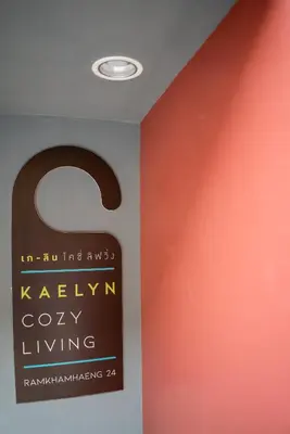 a sign in a room with an orange wall at Kaelyn Cozy Living in Bangkok