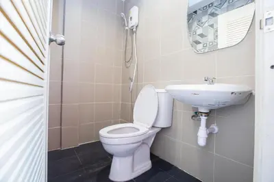 a bathroom with a toilet and a sink at Kaelyn Cozy Living in Bangkok