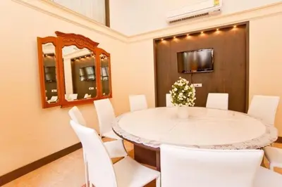 a dining room with a table and white chairs at Siam Paradise Entertainment Complex in Bangkok