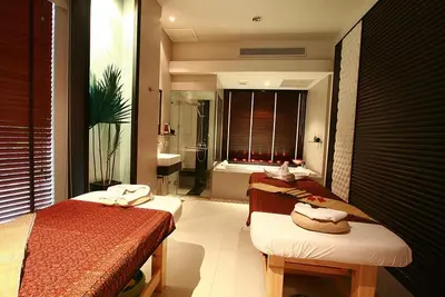 a bedroom with two beds and a bathroom with a tub at Siam Paradise Entertainment Complex in Bangkok