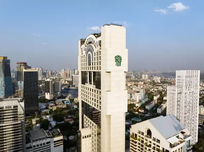 a tall white building with a clock on it in a city at Banyan Tree Bangkok in Bangkok