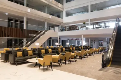 a lobby with chairs and tables in a building at S Ram Leisure Hotel in Bangkok