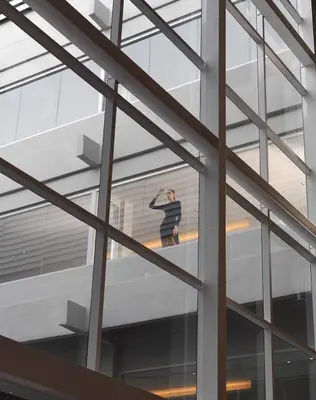 a woman standing on a window in a building at S Ram Leisure Hotel in Bangkok