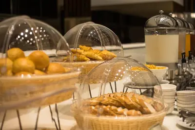 three baskets of bread and pastries on a table at S Ram Leisure Hotel in Bangkok