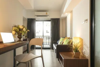 a living room with a couch and a table at The Home Hotel SHA in Bangkok