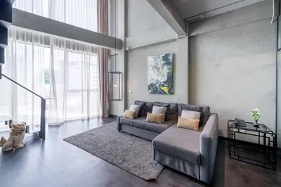 a living room with a couch and a chair at Palette The Ex Capital Hotel Bangkok in Bangkok