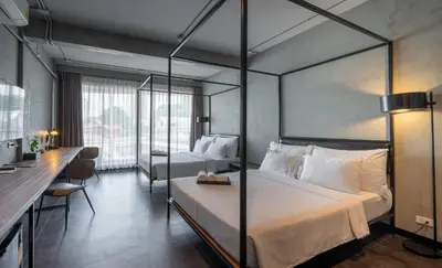 a hotel room with a bed and a desk at Palette The Ex Capital Hotel Bangkok in Bangkok