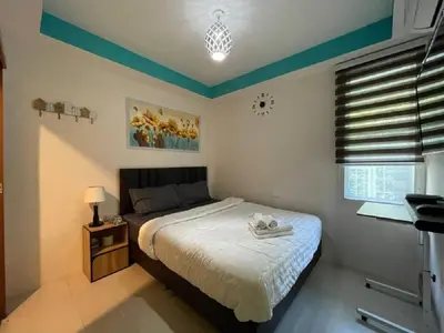 a bedroom with a bed and a lamp and a window at Great House 99 in Bangkok