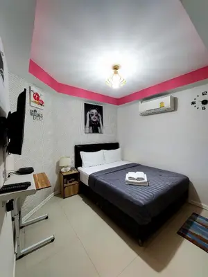 a bedroom with a bed and a desk with a computer at Great House 99 in Bangkok