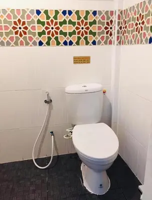 a bathroom with a white toilet and a shower at Great House 99 in Bangkok