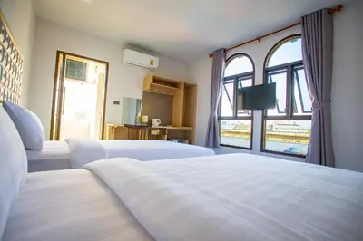 a bedroom with two beds and a large window at Rich8 Hostel in Bangkok