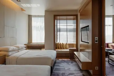 a hotel room with two beds and a window at Marriott Executive Apartments Bangkok, Sukhumvit Thonglor in Bangkok