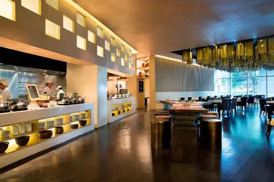 a restaurant with tables and a chef preparing food at Marriott Executive Apartments Bangkok, Sukhumvit Thonglor in Bangkok