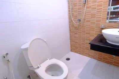 a bathroom with a toilet and a sink at Ploenchit Mansion in Bangkok