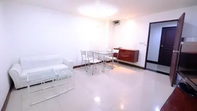 a living room with a white couch and a table at Ploenchit Mansion in Bangkok