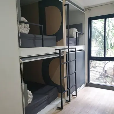 a room with three bunk beds with a window at V30 Sukhumvit in Bangkok