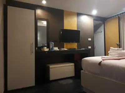 a hotel room with a bed and a television at V30 Sukhumvit in Bangkok