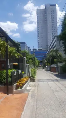a city street with flowers and a tall building at bangkok bed place in Bangkok