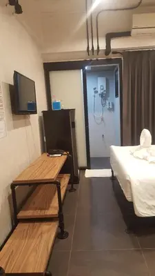 a room with a bed and a table and a tv at bangkok bed place in Bangkok