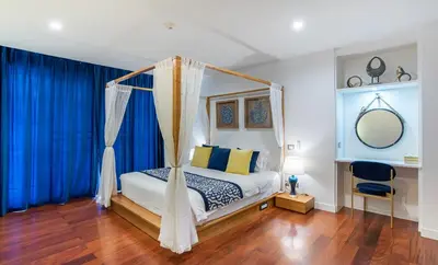 a bedroom with a canopy bed with blue curtains at Benviar Tonson Residence in Bangkok