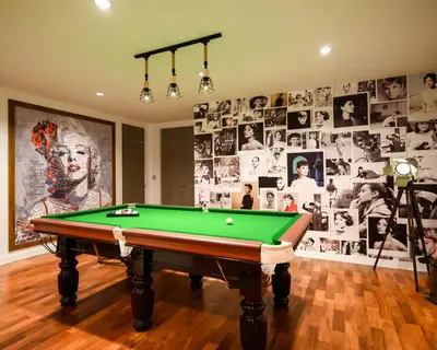 a room with a pool table and a wall of photos at Benviar Tonson Residence in Bangkok
