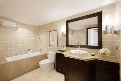 a bathroom with a sink and a toilet and a bath tub at Conrad Bangkok Residences in Bangkok